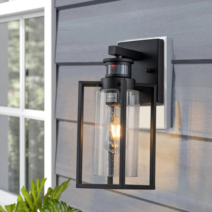 1-Light Matte Black Motion Sensing Dusk to Dawn Outdoor Wall Lanten with Clear Seeded Glass Cylinder
